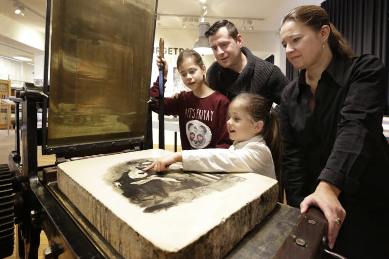 Een aantal bezoekers, waaronder twee kinderen bezoeken het steendrukmuseum in Valkenswaard (bron: KIEN)