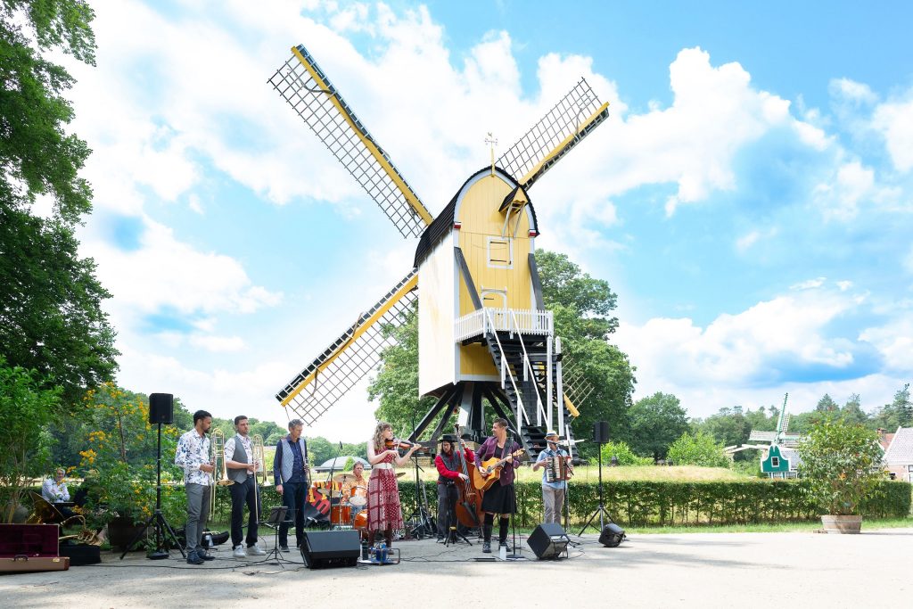 De band Attacca trad buiten op. Het plein voor de gele molen van het Nederlands Openluchtmuseum gaf ruimte voor een prima dansvloer.