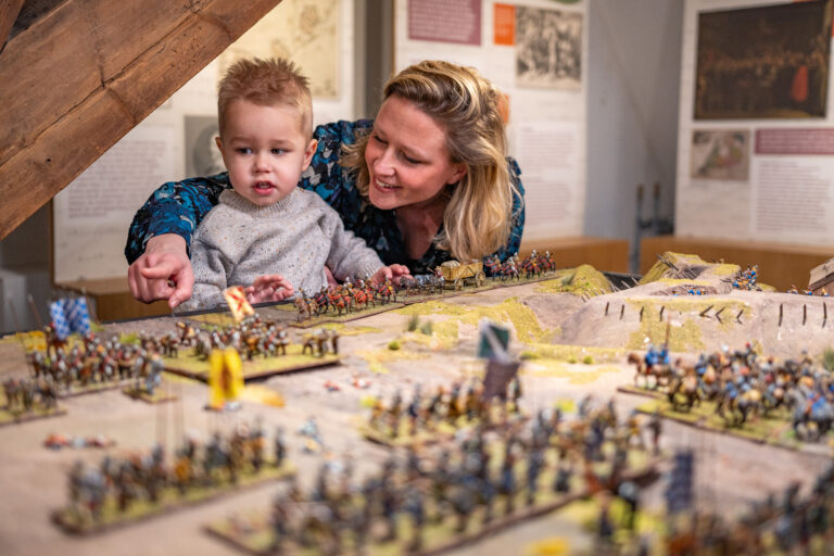 Een vrouw en een kind bekijken een maquette in het museum